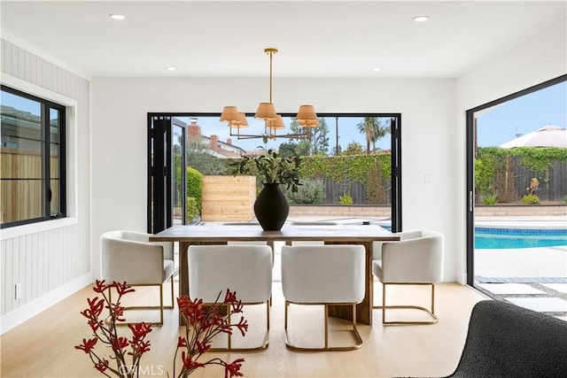 dining space featuring recessed lighting, wood finished floors, and a chandelier