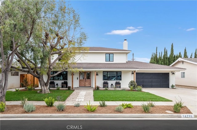 traditional-style home with driveway, a chimney, a front lawn, an attached garage, and stucco siding