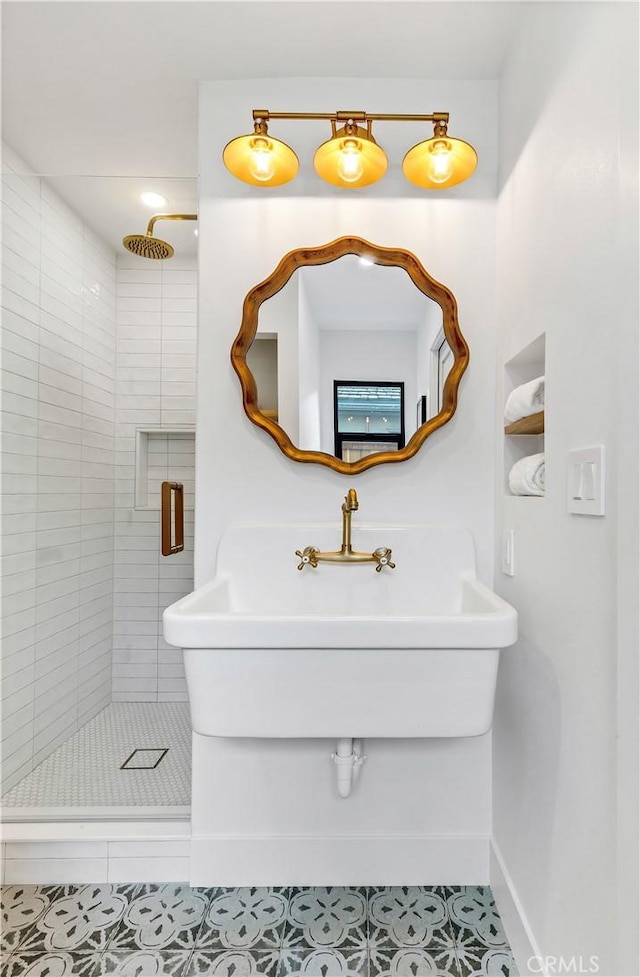 full bathroom with tile patterned flooring, a sink, baseboards, and a stall shower
