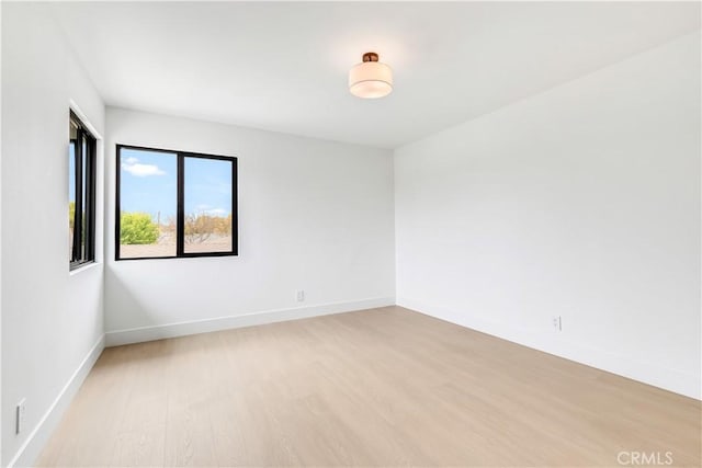 empty room with light wood-style floors and baseboards