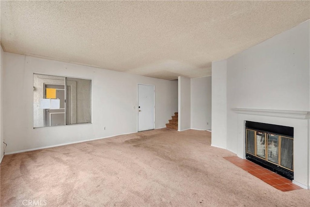 unfurnished living room with carpet floors, a textured ceiling, stairs, baseboards, and a fireplace with flush hearth