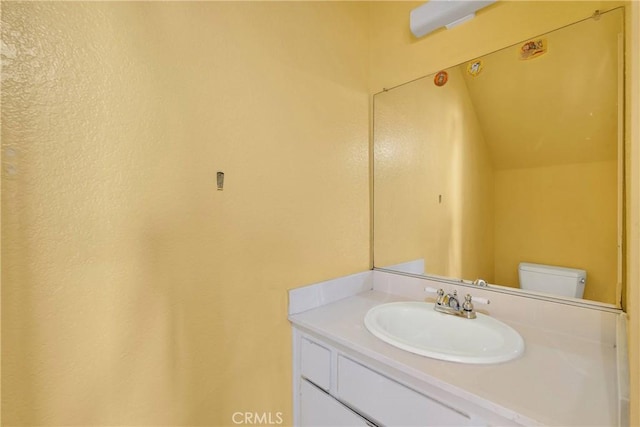 half bathroom featuring vanity and toilet
