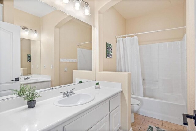 bathroom featuring tile patterned flooring, shower / tub combo, toilet, and vanity