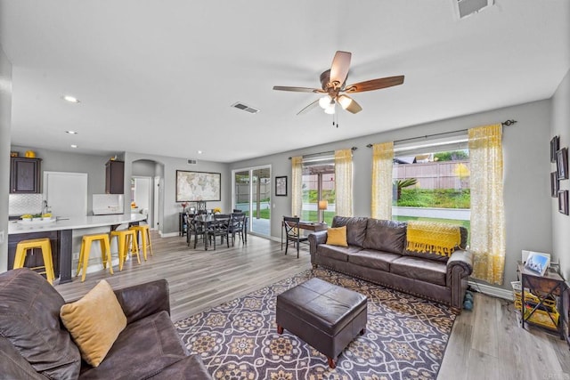 living area with ceiling fan, visible vents, baseboards, and light wood-type flooring