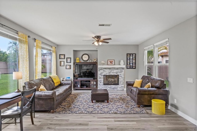 living area featuring visible vents, plenty of natural light, and wood finished floors