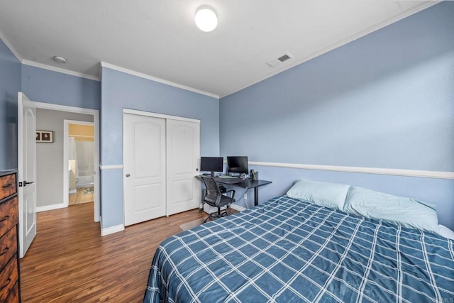 bedroom featuring crown molding, a closet, wood finished floors, and visible vents