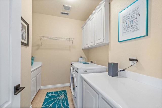 washroom with cabinet space, light tile patterned flooring, visible vents, and washing machine and clothes dryer