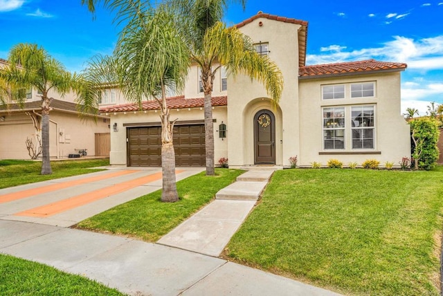 mediterranean / spanish home with a garage, a front lawn, stucco siding, a tiled roof, and driveway