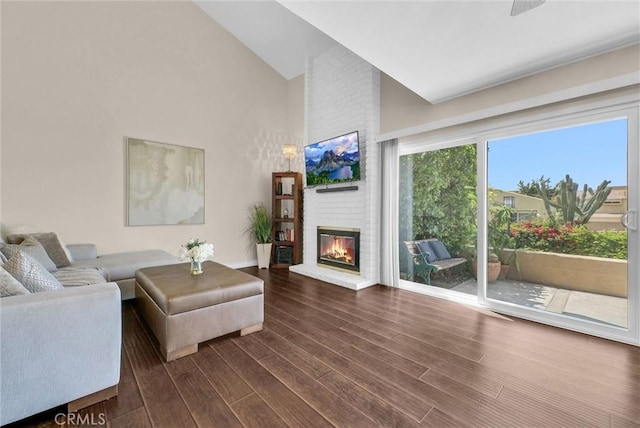 living room with high vaulted ceiling, baseboards, a brick fireplace, and dark wood finished floors