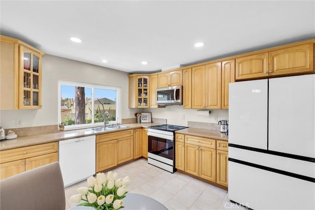 kitchen featuring white appliances, glass insert cabinets, recessed lighting, light countertops, and a sink