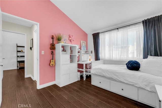bedroom featuring baseboards, vaulted ceiling, and wood finished floors