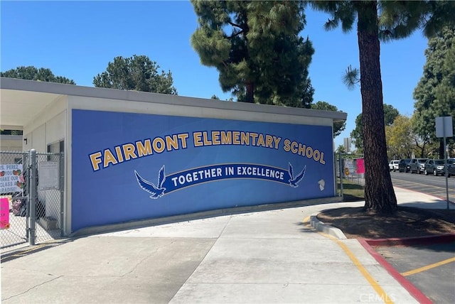 community sign featuring uncovered parking and fence