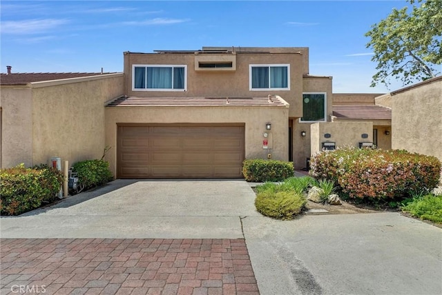 view of front of property with a garage, stucco siding, and concrete driveway