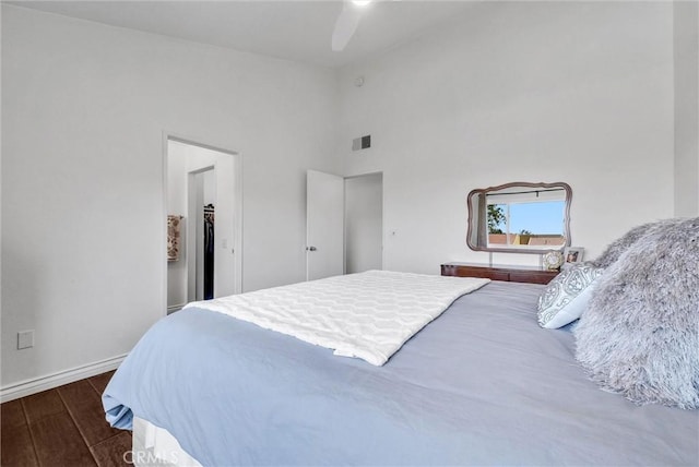 bedroom with ceiling fan, visible vents, wood finished floors, baseboards, and high vaulted ceiling