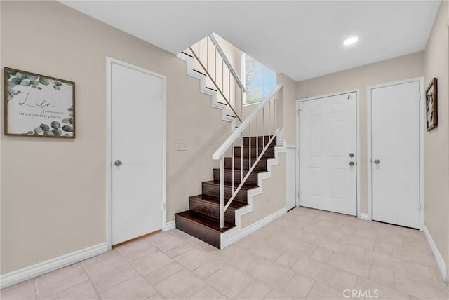 entrance foyer with stairway, baseboards, and recessed lighting