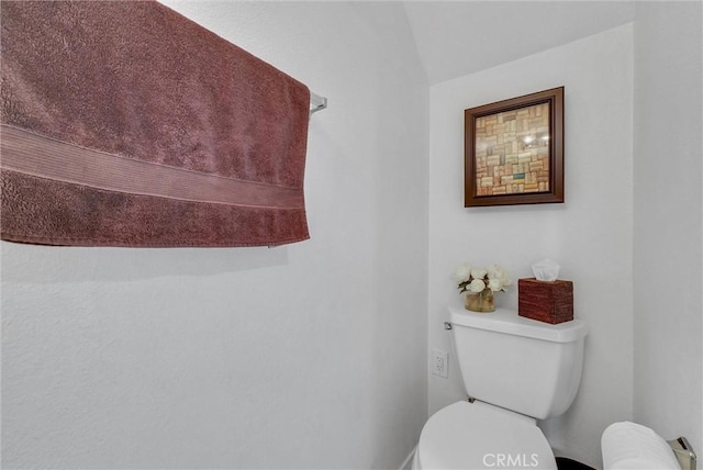 bathroom featuring baseboards and toilet