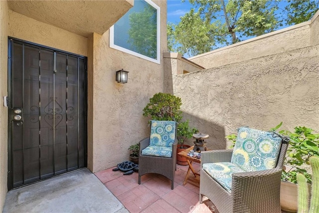 view of exterior entry with stucco siding and a patio area