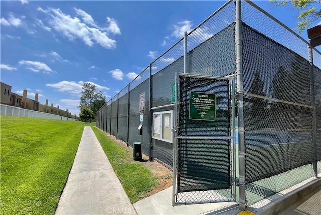 exterior space featuring fence, a gate, and a lawn
