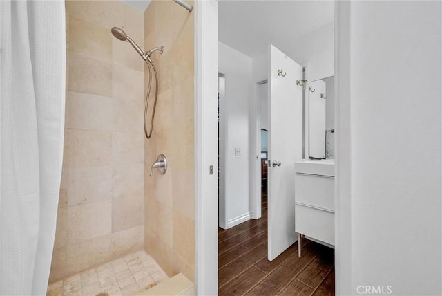 bathroom featuring a tile shower and wood finished floors