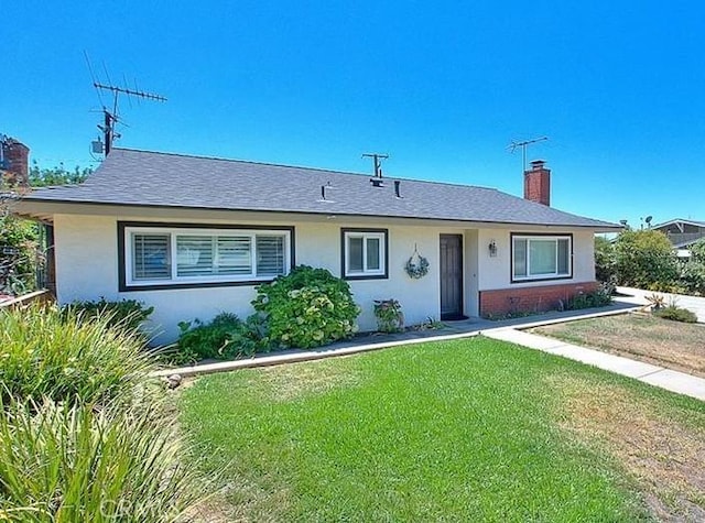 ranch-style house featuring stucco siding, a chimney, and a front lawn