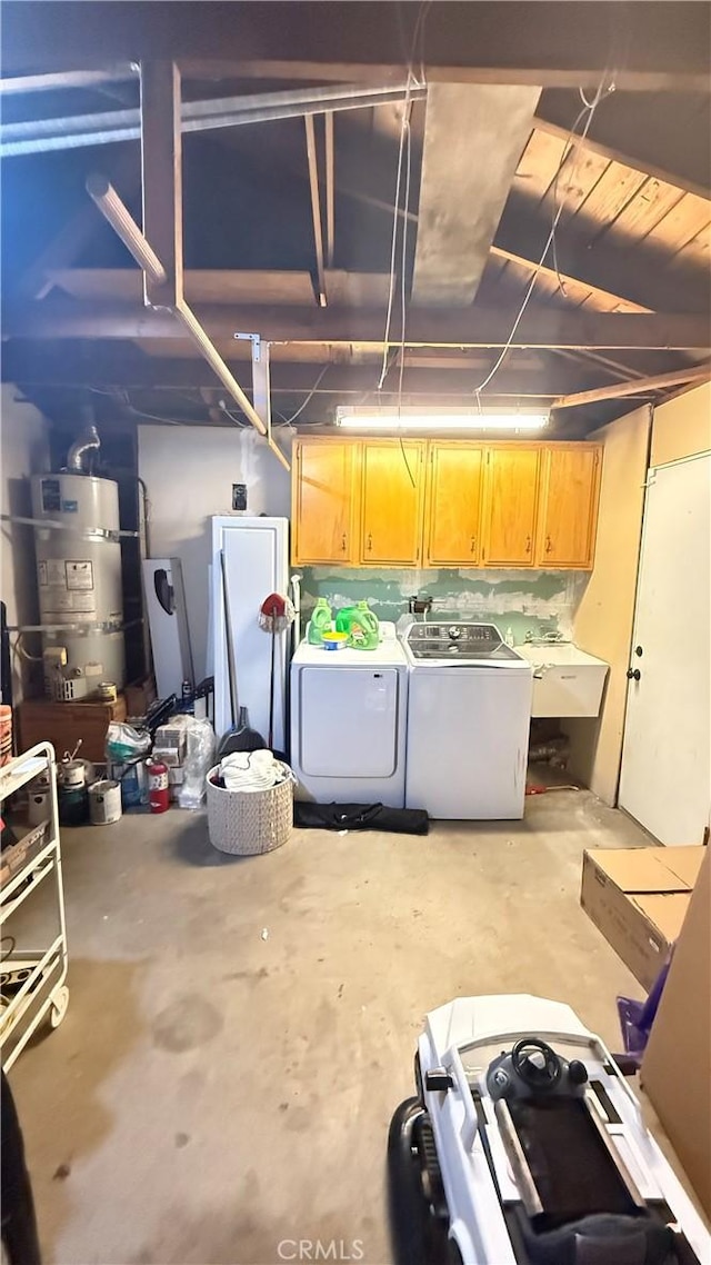 below grade area featuring a sink, secured water heater, and washing machine and dryer