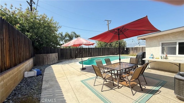 view of patio / terrace with a fenced in pool, outdoor dining space, and a fenced backyard