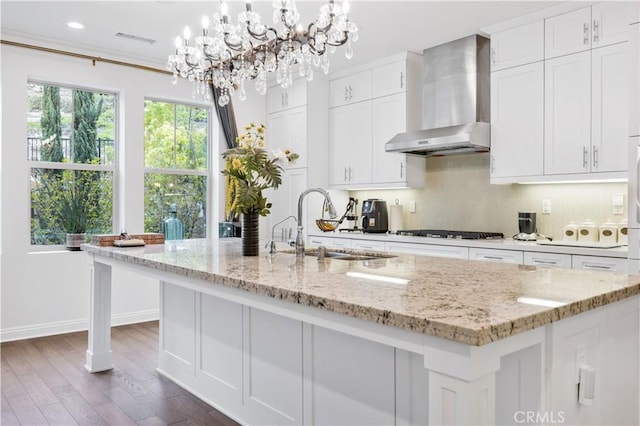 11 Cielo Arroyo, Mission Viejo, CA 92692 - kitchen featuring wall chimney exhaust hood, gas cooktop, white cabinetry, dark wood-style flooring, and a center island with sink
