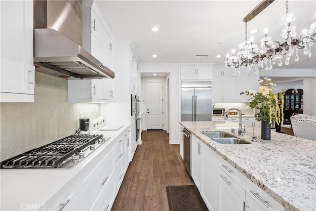 11 Cielo Arroyo, Mission Viejo, CA 92692 - kitchen with wall chimney exhaust hood, appliances with stainless steel finishes, a chandelier, recessed lighting, and white cabinets
