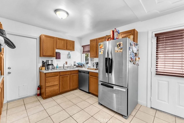 kitchen featuring a sink, light countertops, brown cabinetry, and stainless steel appliances
