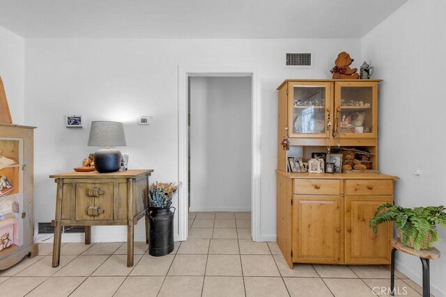 interior space with visible vents, baseboards, and light tile patterned floors