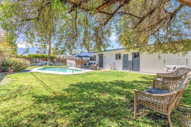 exterior space with stucco siding, a fenced backyard, a fenced in pool, a patio, and a yard
