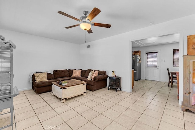 living area with light tile patterned floors, baseboards, ceiling fan, and visible vents