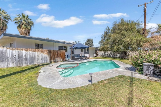 view of pool with a yard, a pool with connected hot tub, a fenced backyard, and a patio area