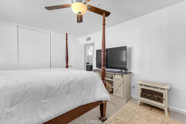 bedroom with baseboards, a textured ceiling, and visible vents