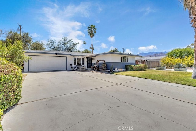 single story home featuring a garage, a front lawn, stucco siding, and driveway