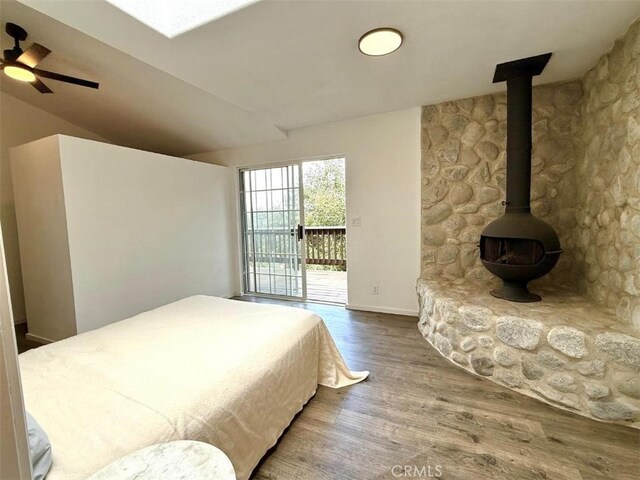 1909 Pioneer Way, Pine Mountain Club, CA 93222 - bedroom featuring access to outside, a wood stove, wood finished floors, and vaulted ceiling