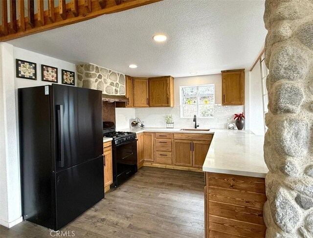 1909 Pioneer Way, Pine Mountain Club, CA 93222 - kitchen featuring black appliances, dark wood-style flooring, light countertops, a textured ceiling, and backsplash