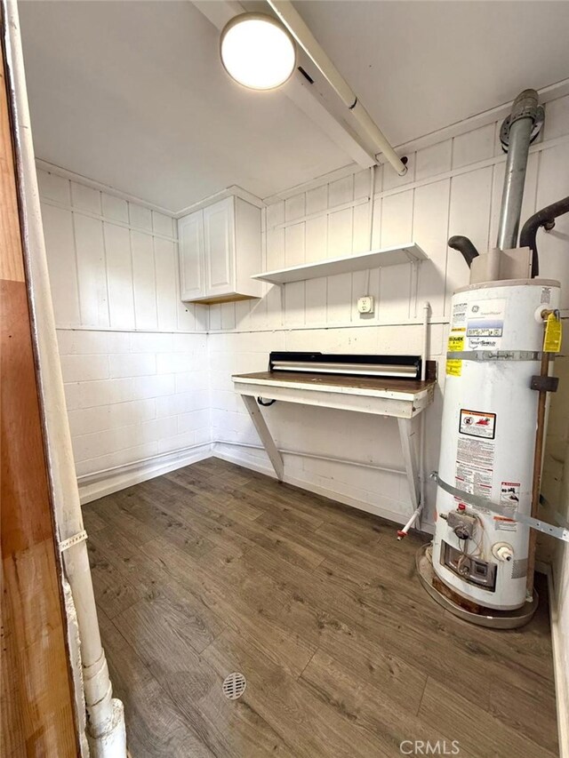 1909 Pioneer Way, Pine Mountain Club, CA 93222 - below grade area featuring water heater, dark wood finished floors, and concrete block wall