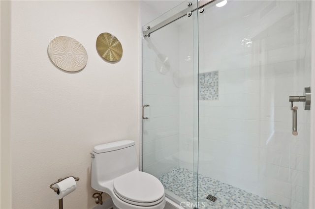 full bath featuring a stall shower and toilet