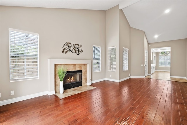 unfurnished living room with baseboards, a fireplace, and wood finished floors