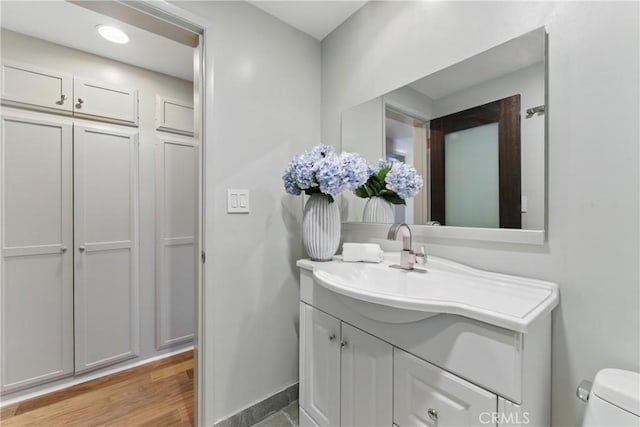 1200 E Ocean Blvd Unit 59, Long Beach, CA 90802 - half bath featuring vanity, baseboards, toilet, and wood finished floors