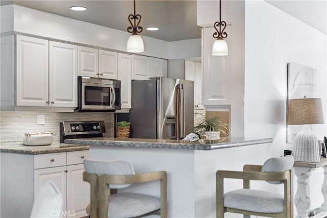 1200 E Ocean Blvd Unit 59, Long Beach, CA 90802 - kitchen featuring stainless steel appliances, a kitchen bar, decorative backsplash, decorative light fixtures, and recessed lighting