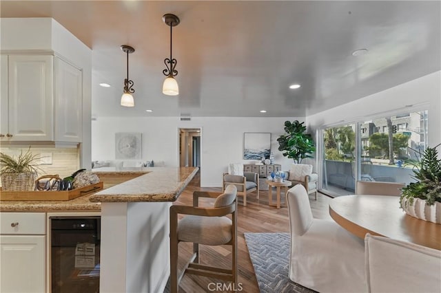 1200 E Ocean Blvd Unit 59, Long Beach, CA 90802 - kitchen featuring tasteful backsplash, wood finished floors, a kitchen bar, decorative light fixtures, and recessed lighting