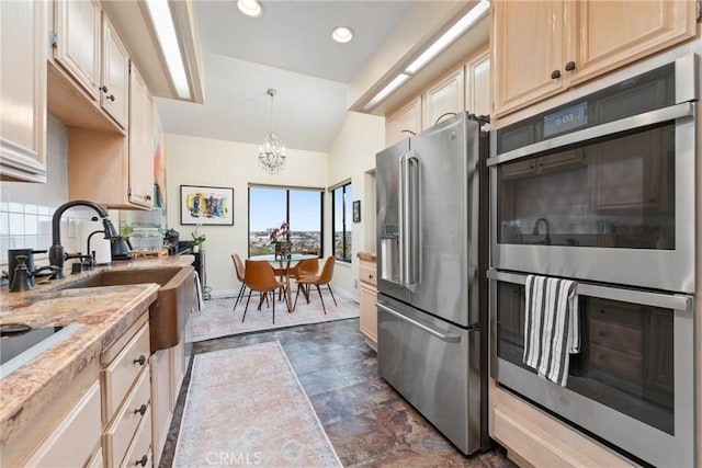 210 Lille Ln Unit 313, Newport Beach, CA 92663 - kitchen with an inviting chandelier, backsplash, stone finish flooring, baseboards, and appliances with stainless steel finishes