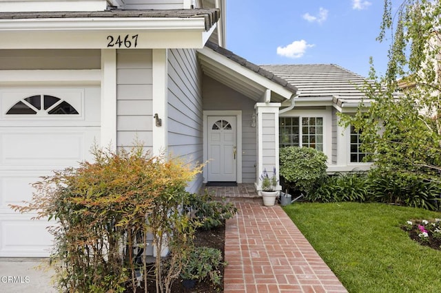 property entrance featuring a yard and an attached garage