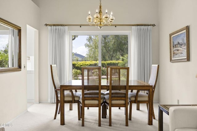 dining area featuring an inviting chandelier, a mountain view, and light colored carpet
