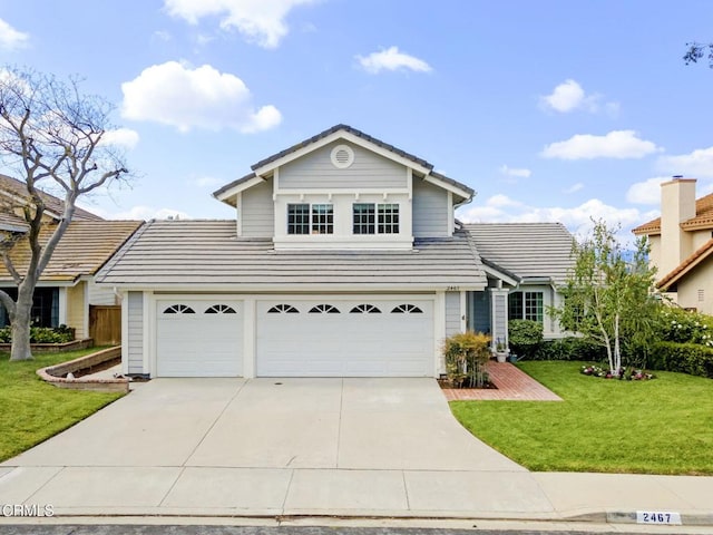 traditional-style home featuring a garage, a tiled roof, concrete driveway, and a front yard