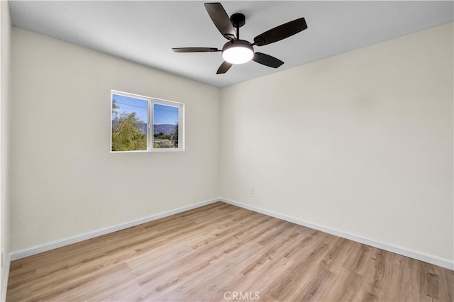 unfurnished room with baseboards, a ceiling fan, and wood finished floors