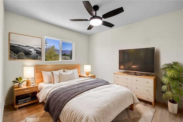 bedroom with baseboards, ceiling fan, and light wood-type flooring
