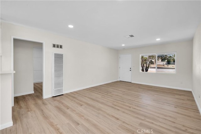 unfurnished living room featuring light wood finished floors, a heating unit, recessed lighting, baseboards, and visible vents